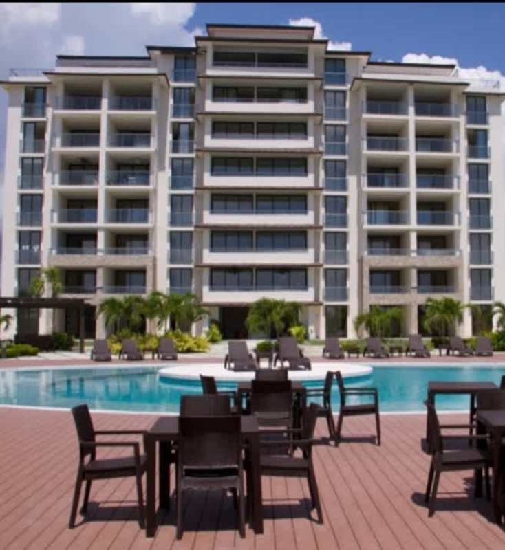 Bright bedroom with city view, mirrored headboard, window and neutral palette PH Perlamar Casamar San Francisco Panama