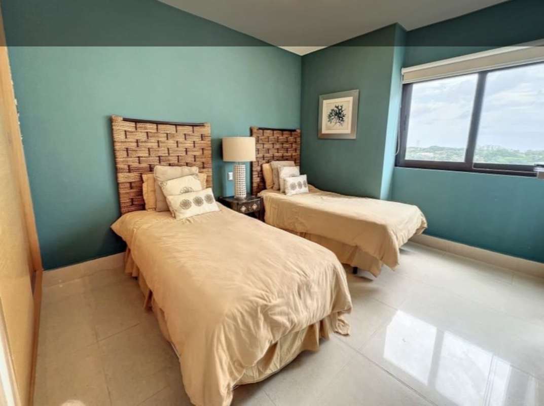 Bedroom with twin beds, woven headboards and city view in PH Perlamar Casamar San Francisco Panama