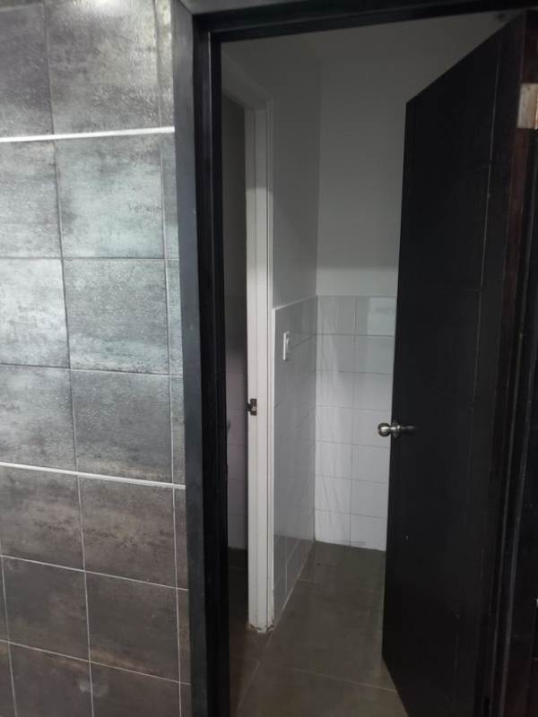 View of private bathroom with ceramic tile walls inside office at Camino de Cruces Panama City