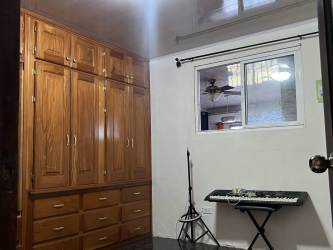 Cozy bedroom with wooden wardrobe and tiled floors corner house Arraiján Panama