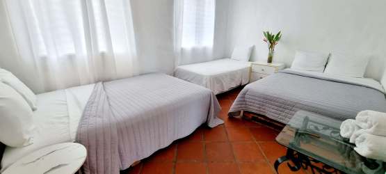 Rustic bedroom with double beds, terracotta tile flooring, natural decor Panama vacation rental