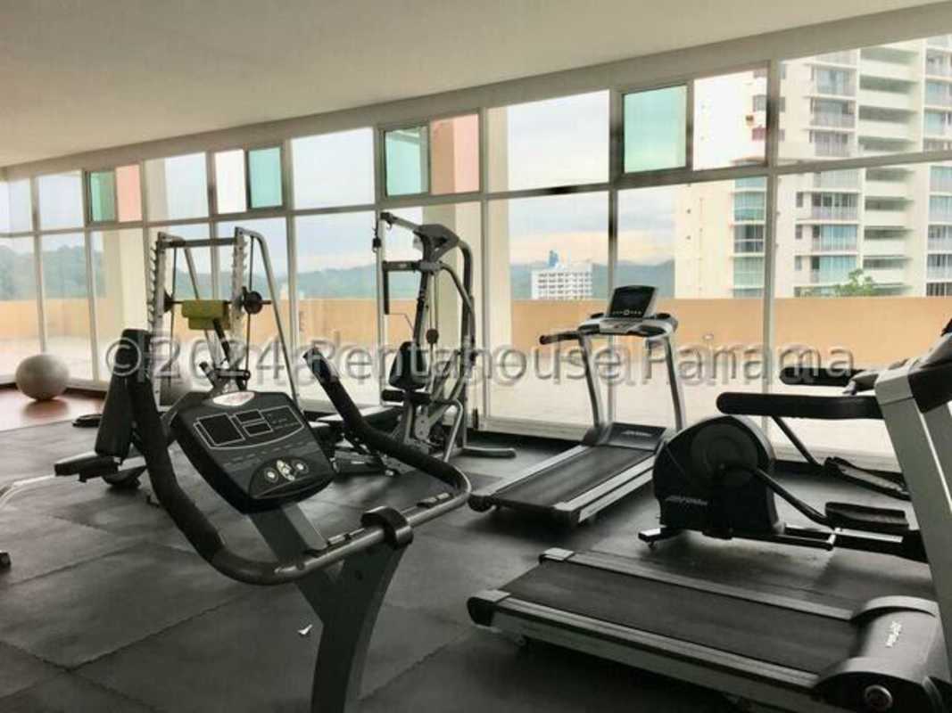 Modern gym with cardio equipment, city skyline views at PH Majestic Gardens Edison Park Panama