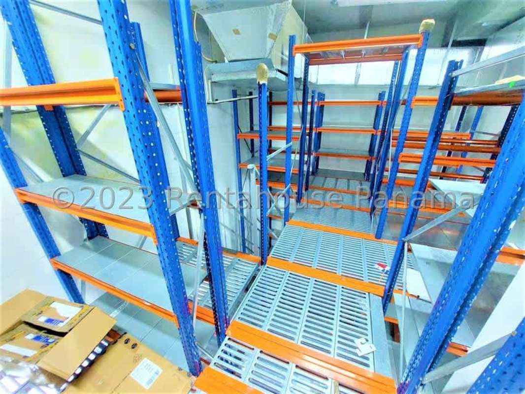 Commercial warehouse interior with blue metal shelving units inside Albrook Mall Panama
