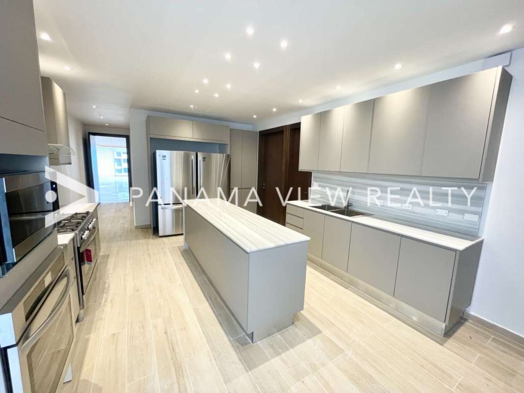 Modern kitchen with neutral tones, marble island, stainless steel appliances at The Towers Punta Paitilla