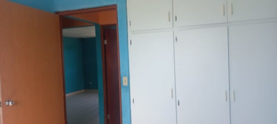 Bedroom with blue walls, white wardrobes in affordable house Villa Llano Marin, Penonomé Panama