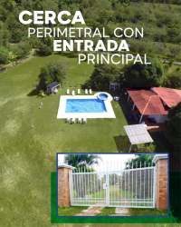 Aerial view showing fenced estate property with entrance gate, large green areas and countryside in San Carlos Panama