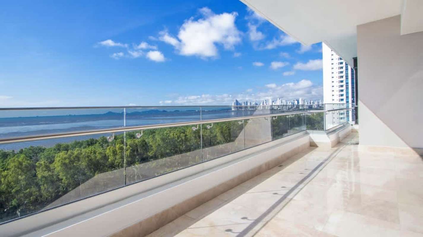 Spacious modern balcony with glass railing overlooking Pacific Ocean and city skyline Costa del Este Panama