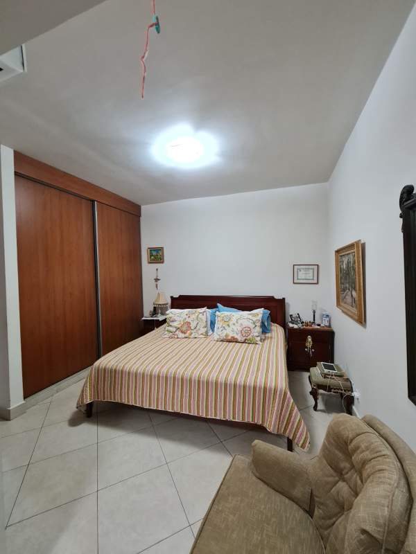 Traditional bedroom with wooden closet and tiled floors in Embassy Club Clayton