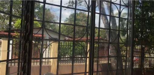 Garden view through window with security grille Panama house rental