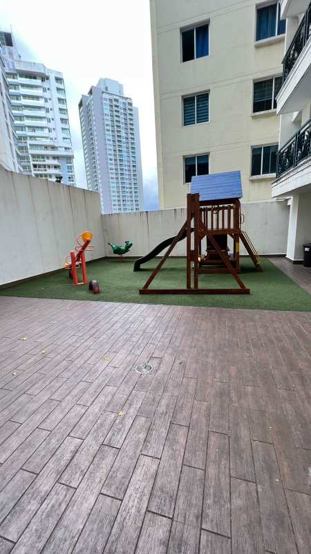 Outdoor children play area with slide and swings in courtyard of PH Belview Edison Park Panama