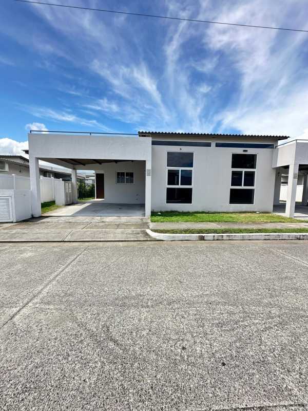 Bright modern kitchen with granite countertops, wood cabinets, and tiled flooring in a Costa Sur house Panama