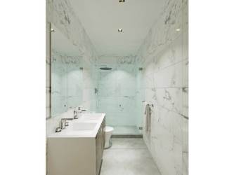 Bathroom with marble walls, double sinks and walk-in shower at Explora Panama Pacifico