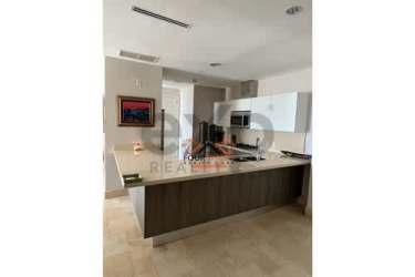 Dining area with glass table overlooking the ocean through large windows at PH Puntarena Buenaventura
