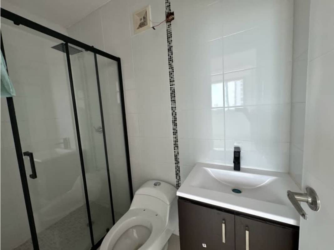 Bathroom with glass enclosed shower, dark vanity, mosaic tile strip in Panama