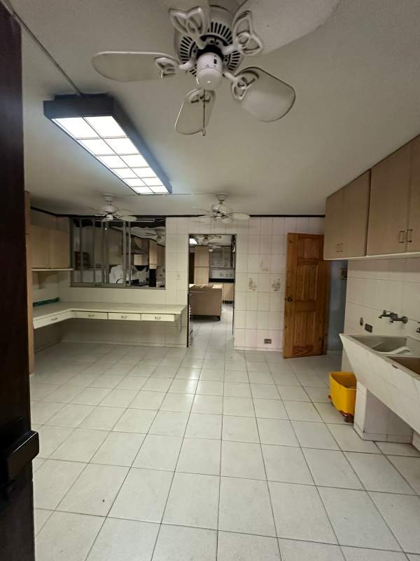 Large traditional kitchen with island, tiled floors and cabinetry in commercial house Obarrio Panama