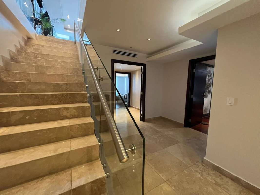Modern staircase with marble floors and glass railing in PH BICSA Tower duplex apartment