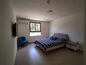 Minimalist bedroom with large window striped bedding and AC Panama Pacifico