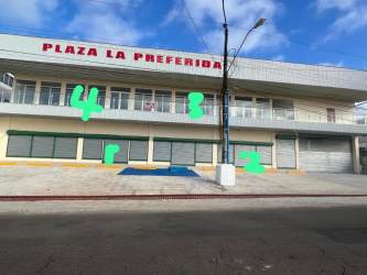Two-story commercial building Plaza La Preferida with multiple storefronts and parking in Costa Verde Colón