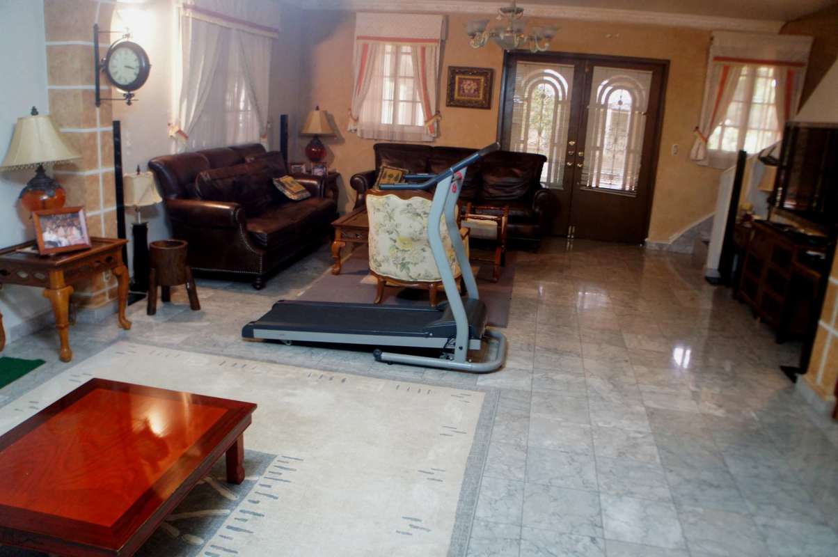 Living room with double doors, marble floor, large windows, and classic furniture in Los Rios Panama