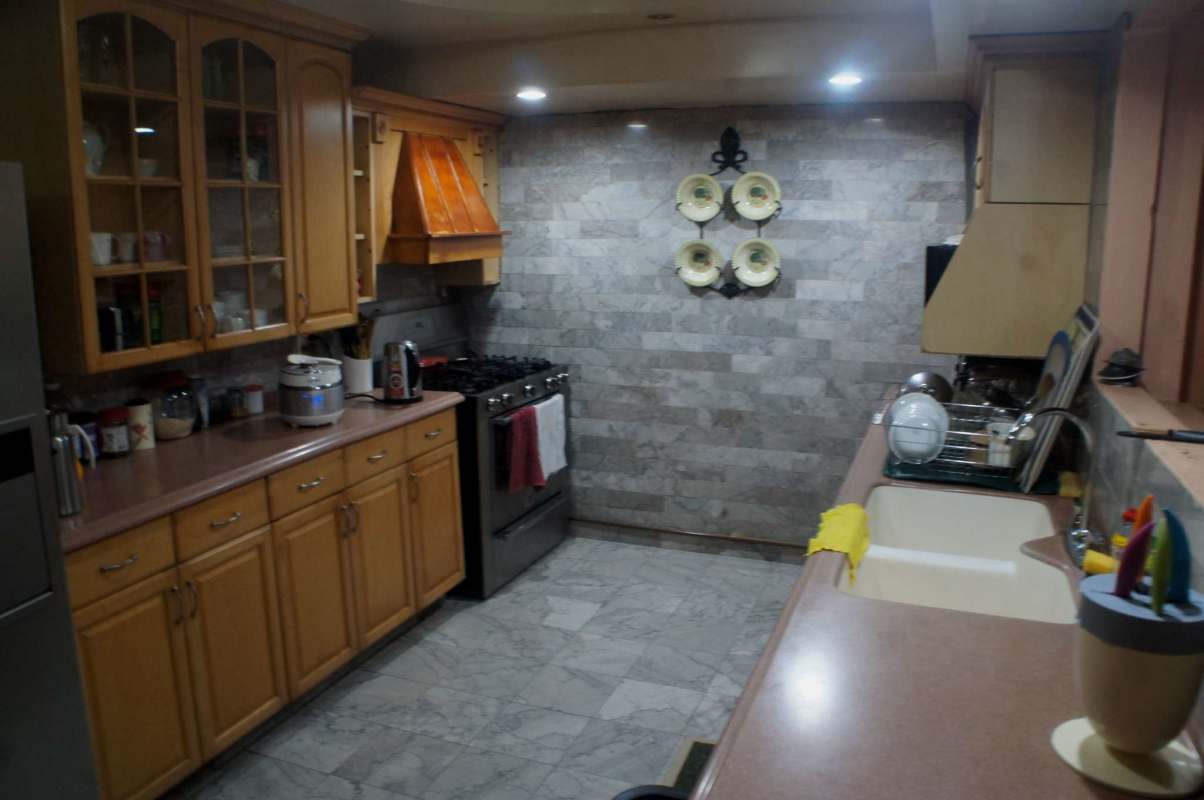 Laundry room with utility sink, LG washer, tile backsplash, and storage in Los Rios home Panama