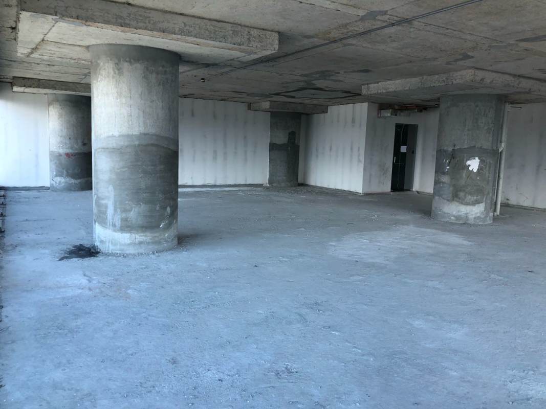Unfinished open floor commercial office space with concrete floors and columns in Oceania Business Plaza