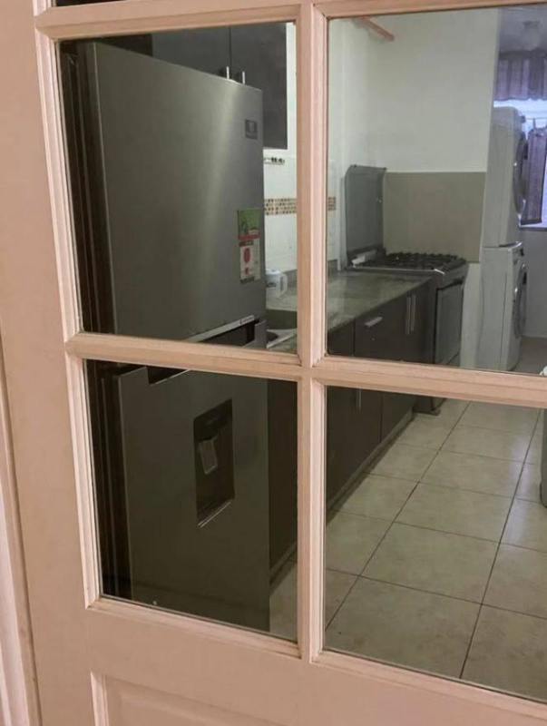 Kitchen with modern appliances, stacked washer dryer and glass door PH Metro Tower Panama City