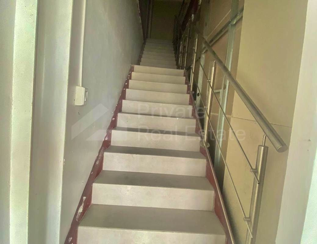 Interior stairwell inside commercial retail unit with metal handrails and grey steps in Midtown Plaza Panama