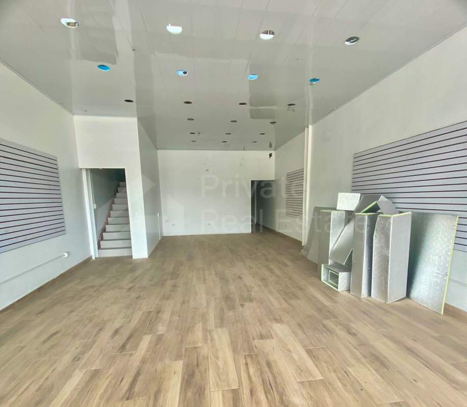 Open retail interior with wood look floors, white walls and staircase to mezzanine Midtown Plaza Panama City