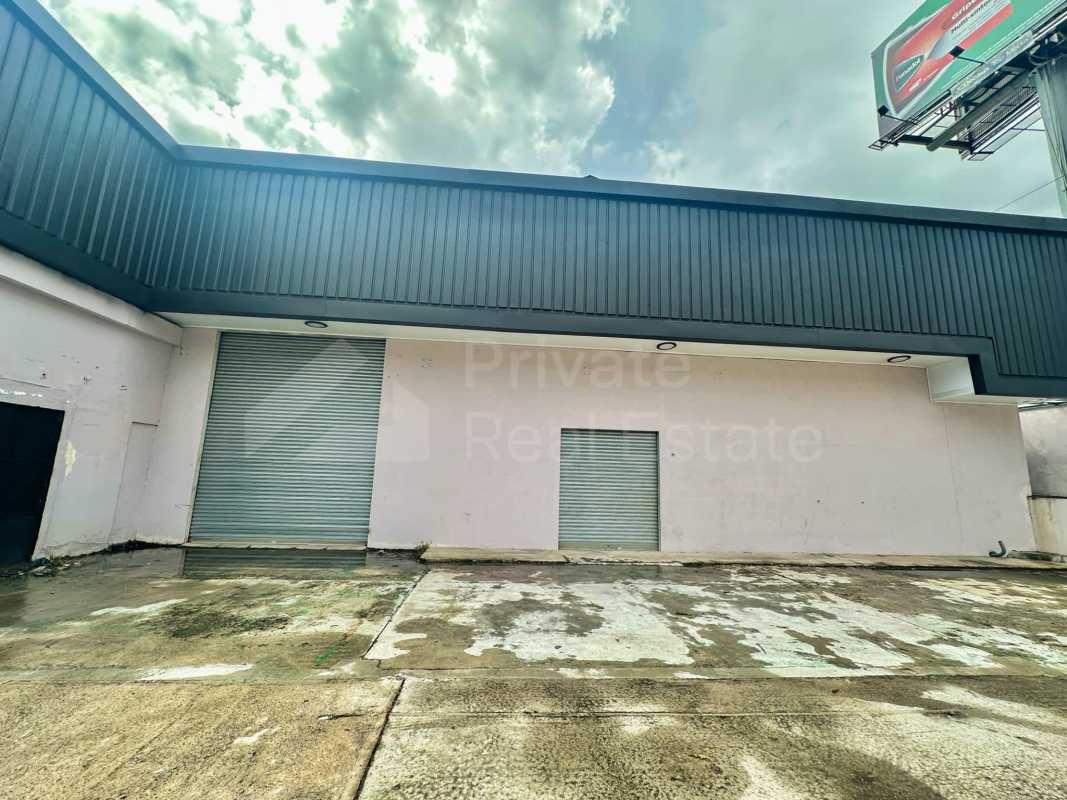 Exterior of warehouse with rolling shutter doors and concrete driveway Tumba Muerto Panama