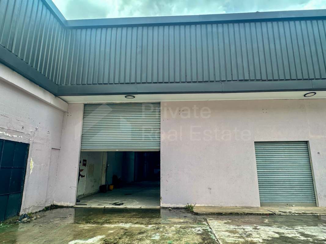 Warehouse with large metal gates, concrete yard frontage in Panama City industrial zone