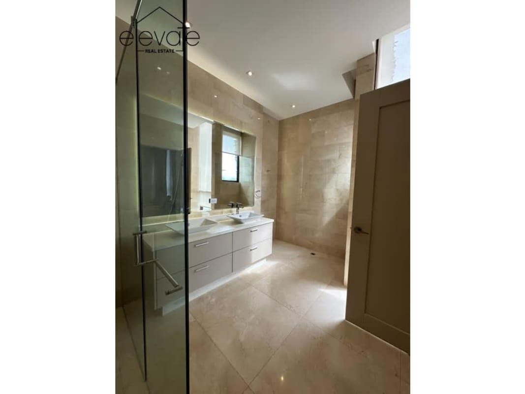 Modern bathroom with double vanity and glass shower in Gardens Punta Pacifica Ocean Reef Panama