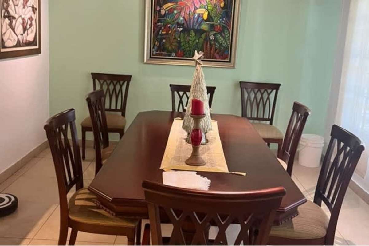 Dining room with wooden table, festive centerpiece and classic accents in Ancón house Panama City