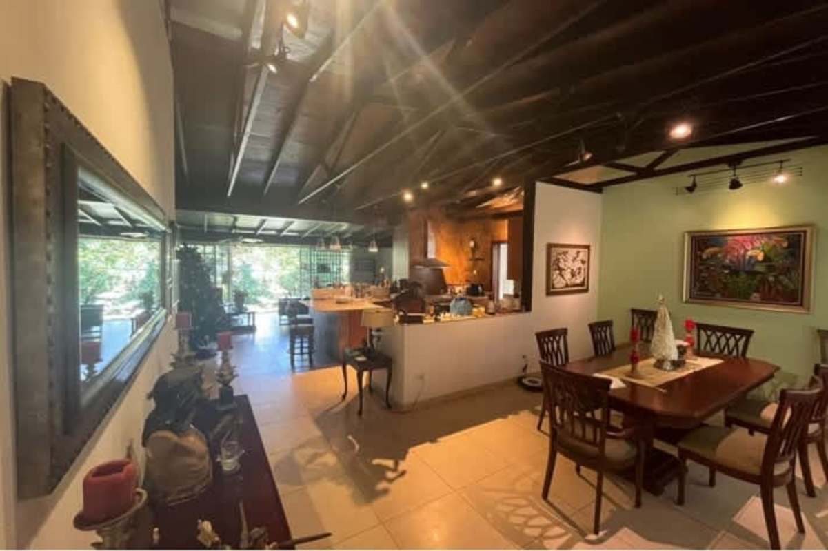 Spacious living room with large windows, ceiling fan, wooden beams, garden view in Llanos de Curundú house Panama City