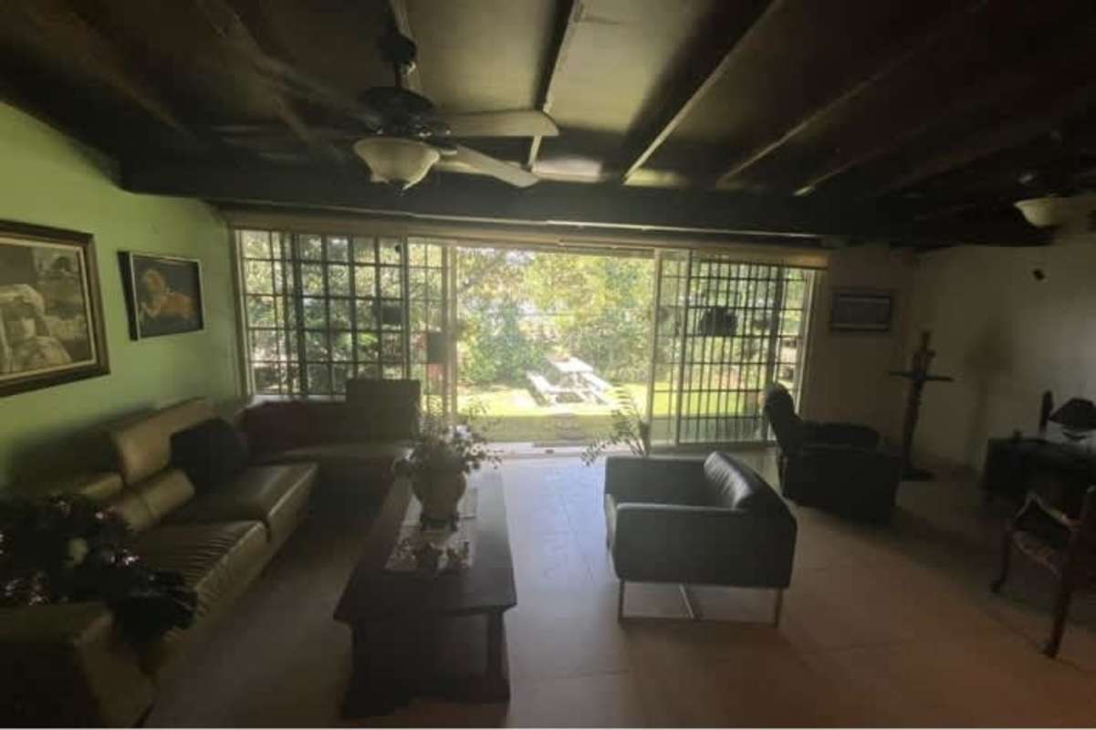 Home office with glass doors, desk, mesh chairs overlooking garden in furnished house Llanos de Curundú Panama