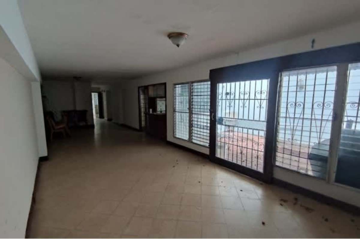 Traditional kitchen with pass-through window wooden cabinets tiled backsplash PH Residencial El Carmen Panama