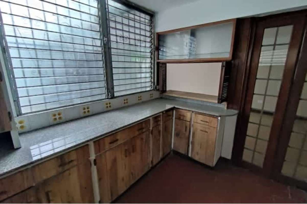 Bright kitchen with double sink louvered windows and wood cabinetry in PH Residencial El Carmen