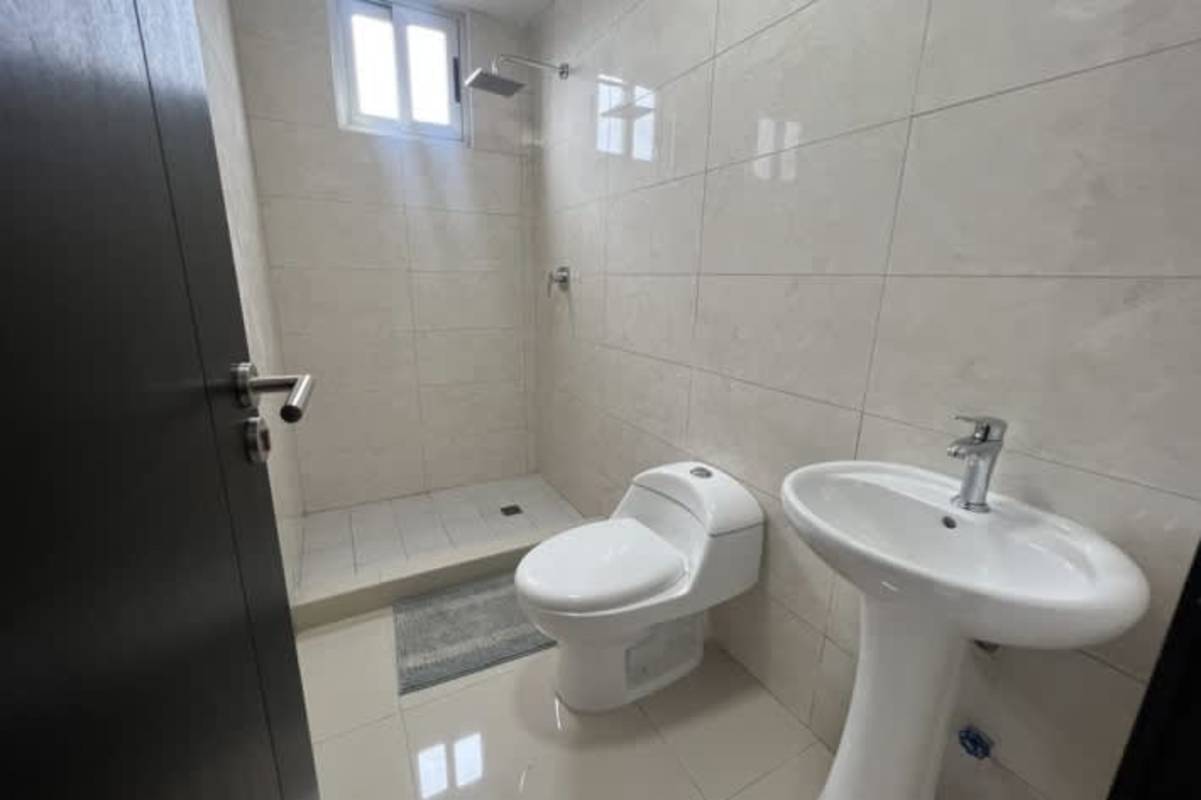 Minimalist tiled bathroom with walk-in shower and pedestal sink PH Calidonia Panama City