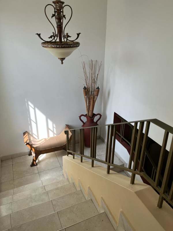 Stair landing with chandelier, window and iron railing in Panama house