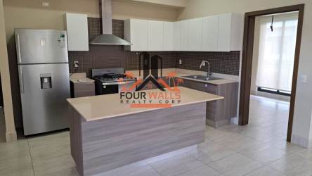 Modern kitchen with central island, stainless steel fridge, gas stove in Panama Pacifico apartment