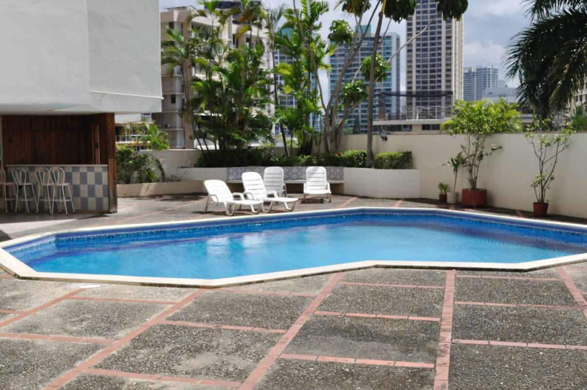 Swimming pool with BBQ area, lounge seating and skyline background at PH Viscaya Punta Paitilla