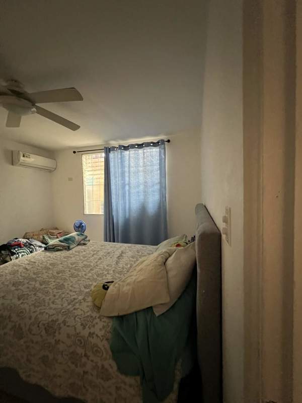 Main bedroom with ceiling fan AC unit large window in Brisas del Golf Panama house