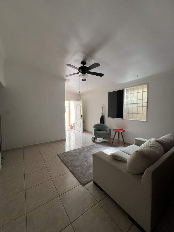Living room with large glass block accent window cream sofa red side table Brisas del Golf