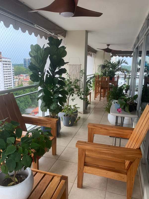 Family den with wood accent wall, flat-screen TV, eclectic design PH Andros Tower Panama