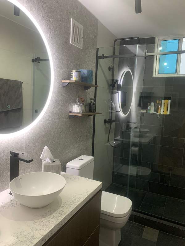 Modern bathroom with illuminated mirror, vessel sink and glass shower in EL Cangrejo Panama
