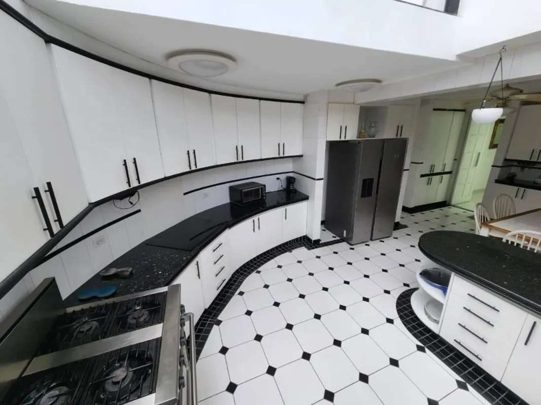 Modern kitchen with white cabinets, granite counters and breakfast bar in Betania house Panama City