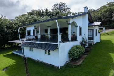 Spacious living room featuring wood-burning fireplace and vaulted ceilings in renovated mountain home Boquete Panama