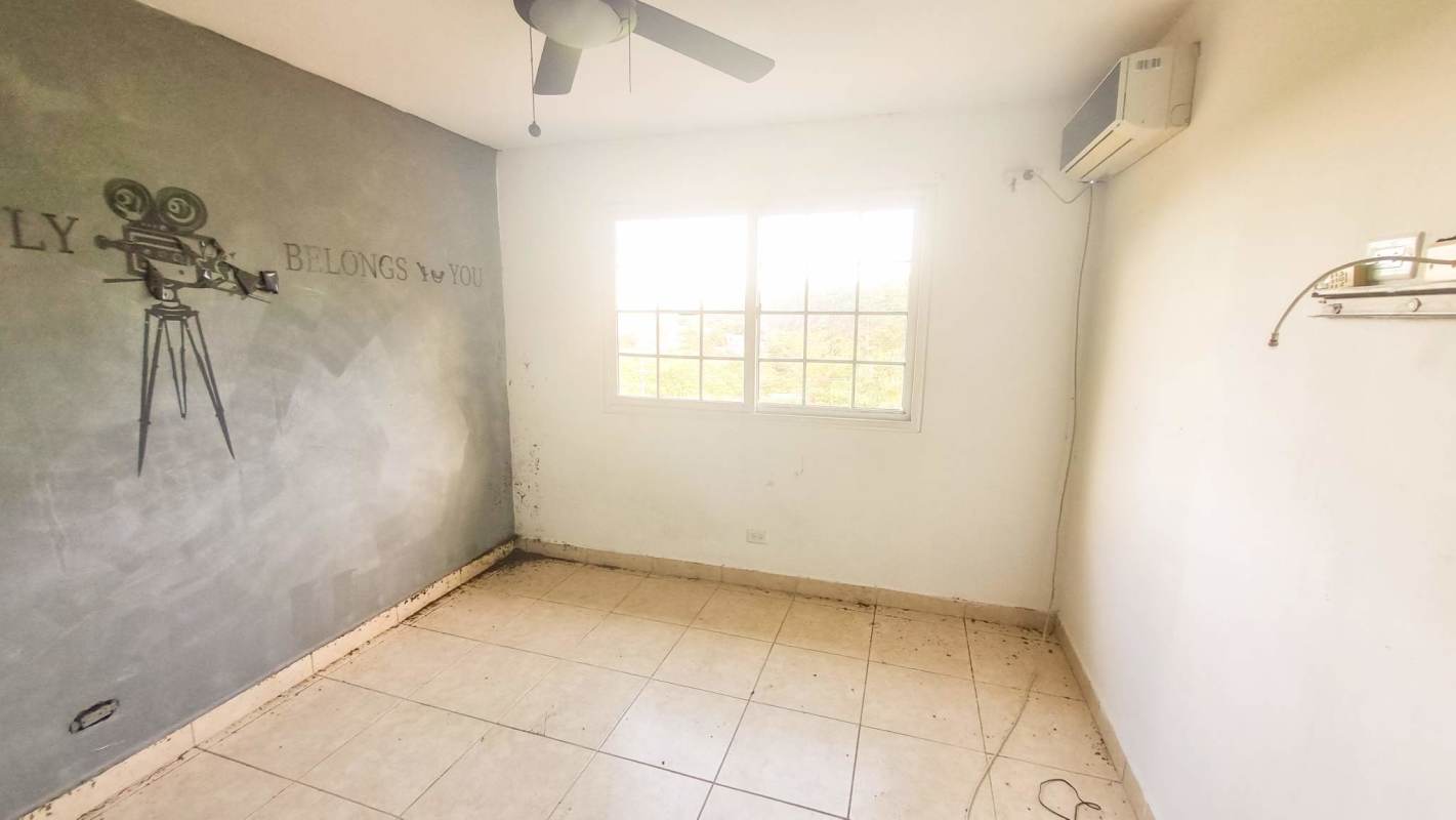 Bedroom with split AC, tile floor, large window in Panama foreclosure house Residencial El Limajo