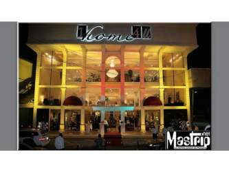 Nighttime exterior of commercial multi-level building with lighting Via Panamericana Panama