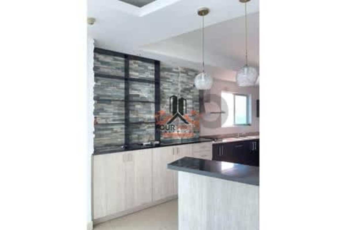 Modern kitchen with pendant lights, stone wall, glass shelves and large window in PH The View Panama