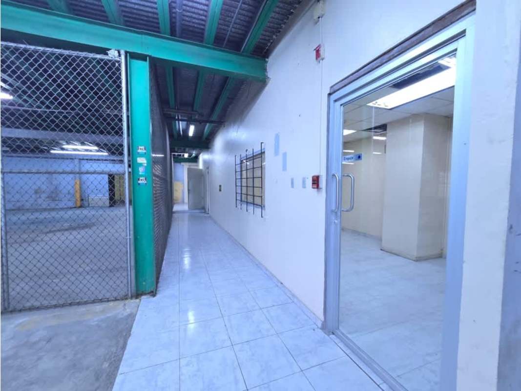 Industrial hallway connecting warehouse sections with fence partition and security door Avenida Justo Arosemena Panama